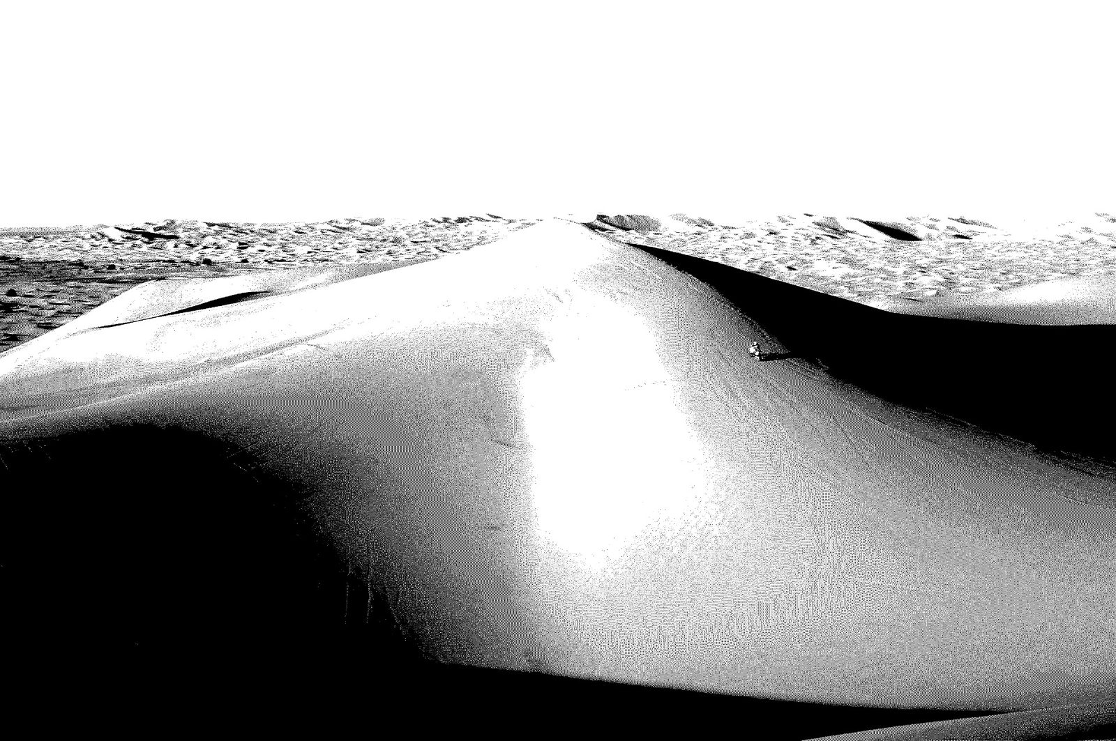 Lone rider crossing a large dune field, shot in high-contrast black and white, from the Tuareg Rallye